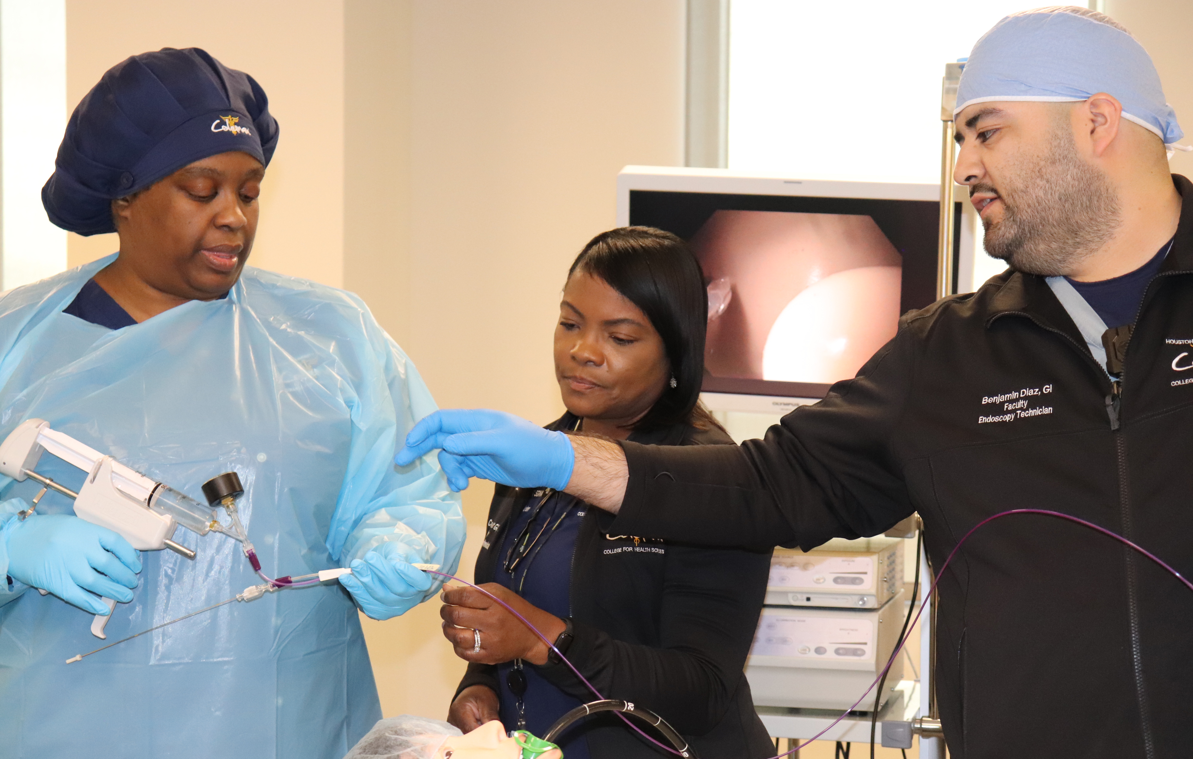 Two Endoscopy Technician instructors teach a student a procedure.